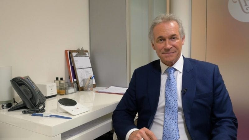 Dr. Hilary Jones with a personal alarm in his office