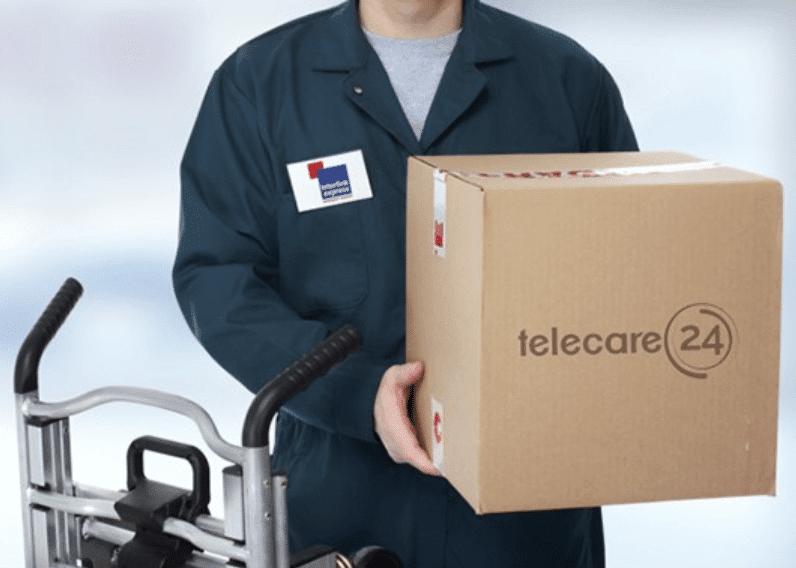 A delivery man holding a package marked with the Telecare24 logo