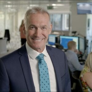 Dr Hilary Jones standing in the Telecare24 monitoring centre smiling at the camera