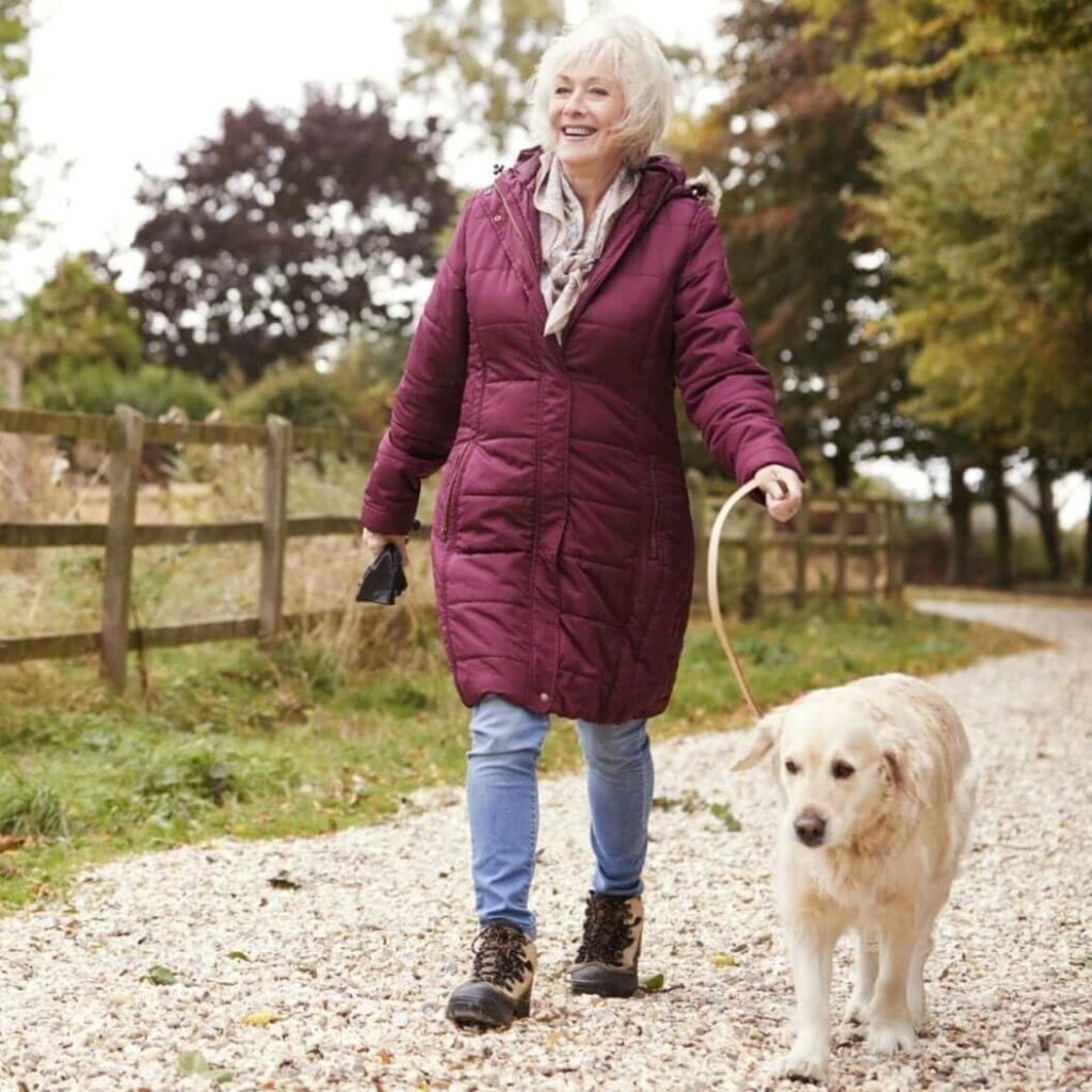 An older woman walking her dog