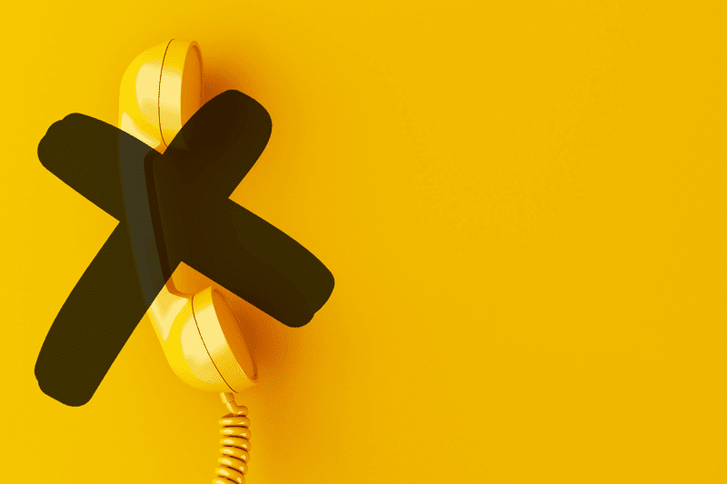A yellow landline telephone crossed out
