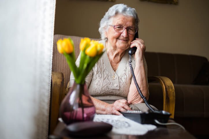 elderly woman using a telephone