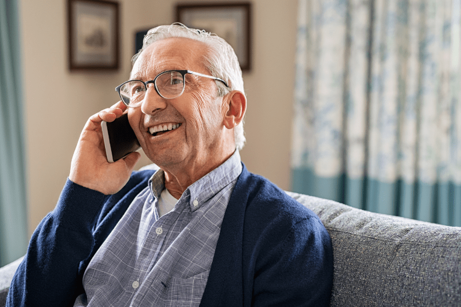 Elderly man talking with his children on phone