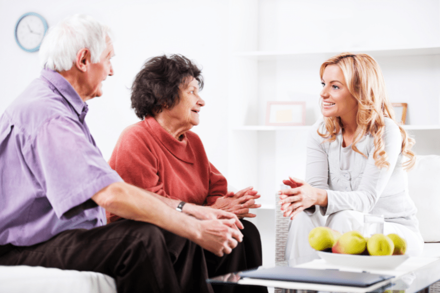 elderly couple talking with a lady