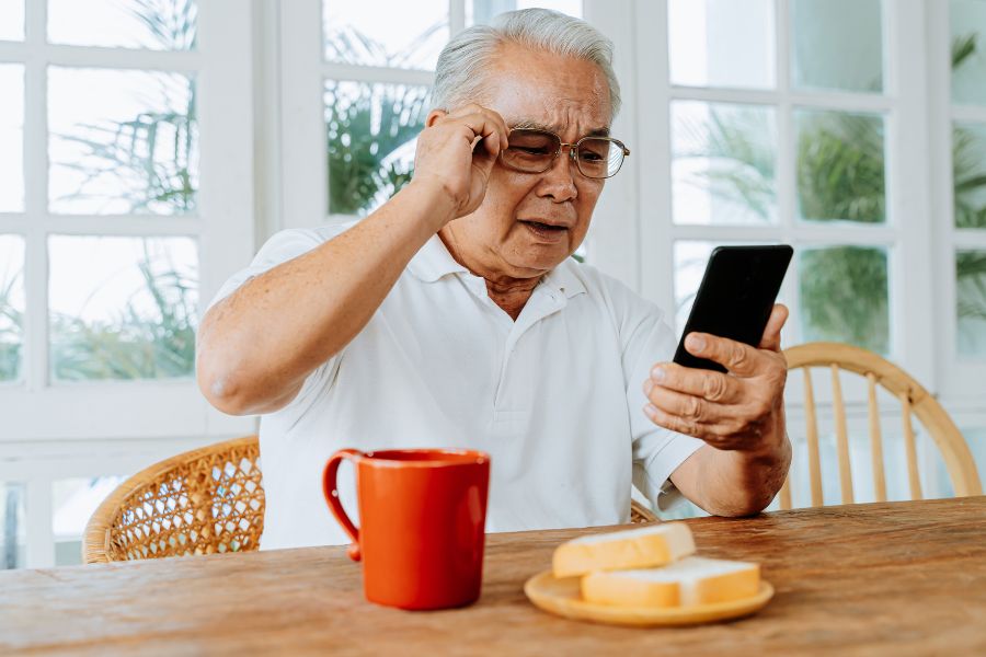An Elderly person selecting fall alarm from his mobile