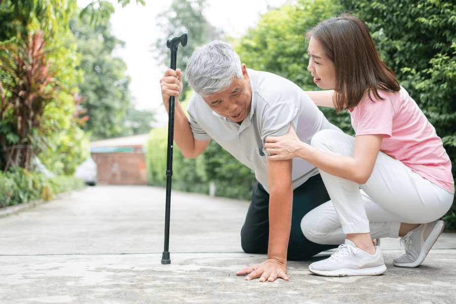 An elderly falling being assisted by a girl