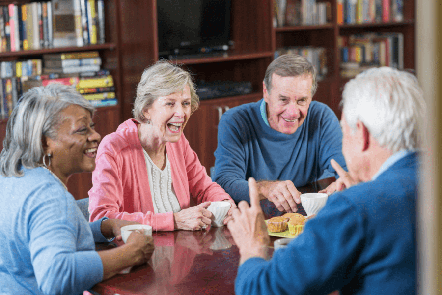 A group of older people having tea together to combat loneliness