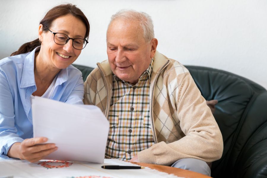 woman-explaining-info-on-paper-to-elderly-man