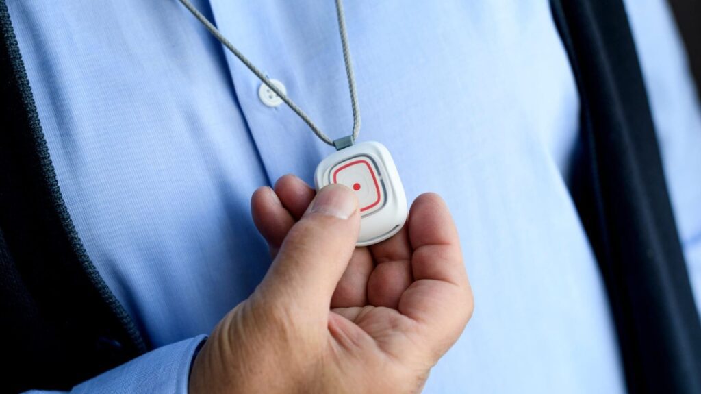 Person pressing on the 'Smile' personal alarm pendant button
